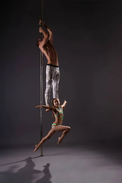 Poledancers making exercises on pylon studio shot — Stock Photo, Image