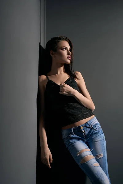Sexy Mädchen in Spitzentop und zerrissenen Jeans im Studio — Stockfoto
