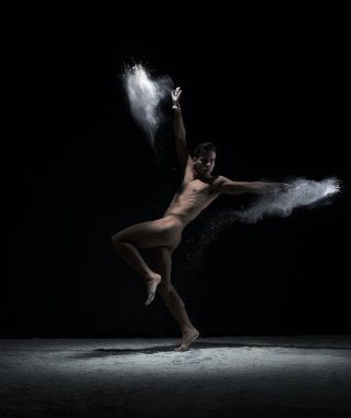Çıplak dansçı toz bulutu içinde hareket