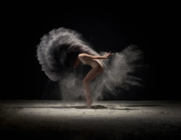 Danseuse se déplaçant dans un nuage de poussière blanche au studio — Photo