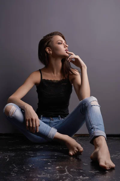 Σέξι κοπέλα με δαντελένια μπλούζα και σκισμένο τζιν στο στούντιο — Φωτογραφία Αρχείου