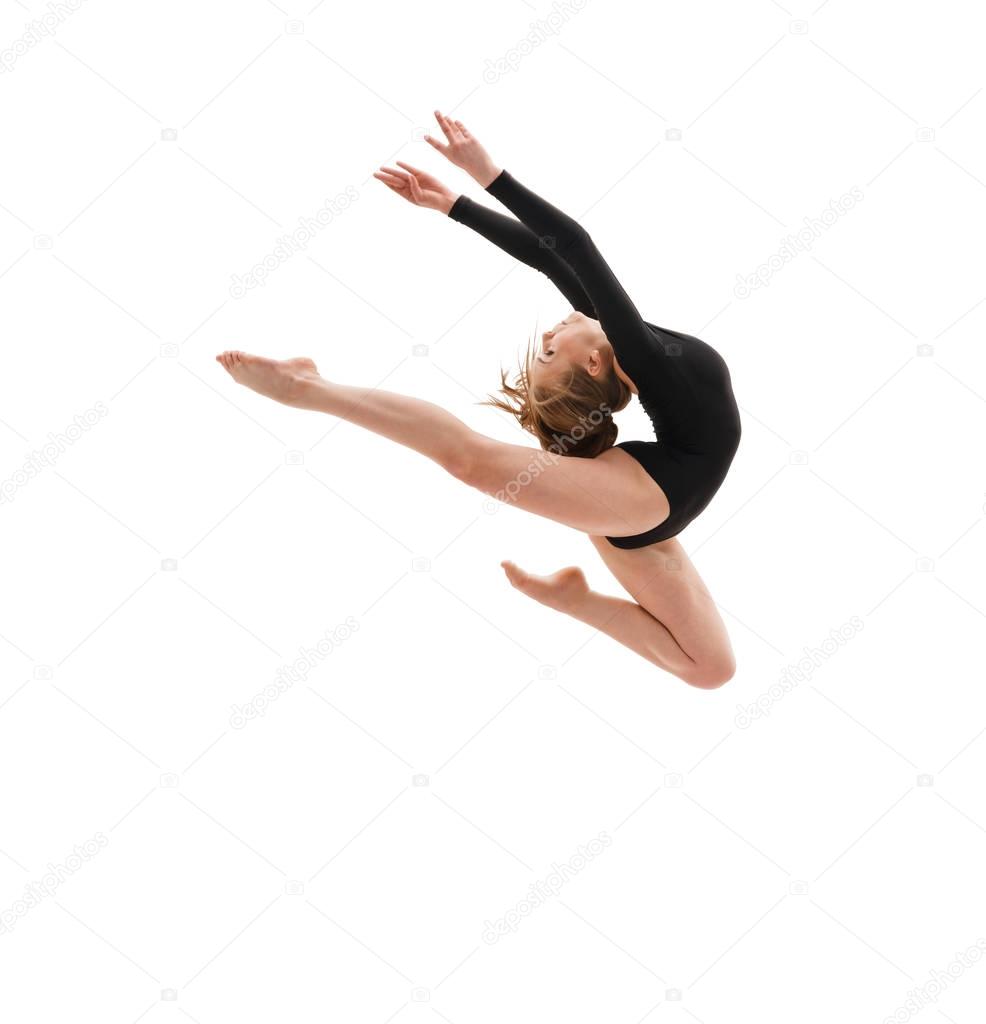 Young slim gymnast in gracefull jump studio shot