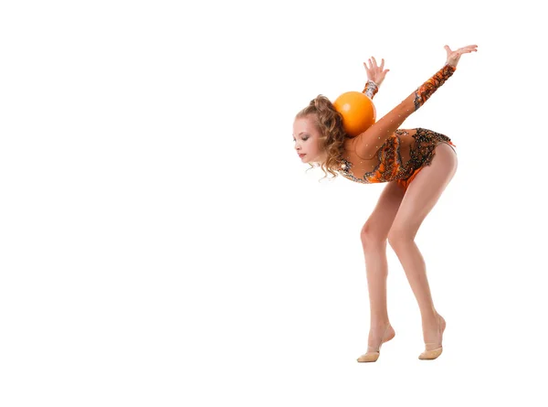 Ung smal gymnast med gula bollen studio skott — Stockfoto