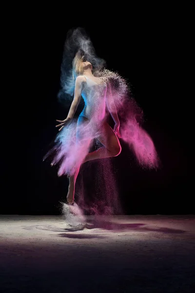 Młoda dziewczyna skoki w chmurze pyłu kolor w studio — Zdjęcie stockowe