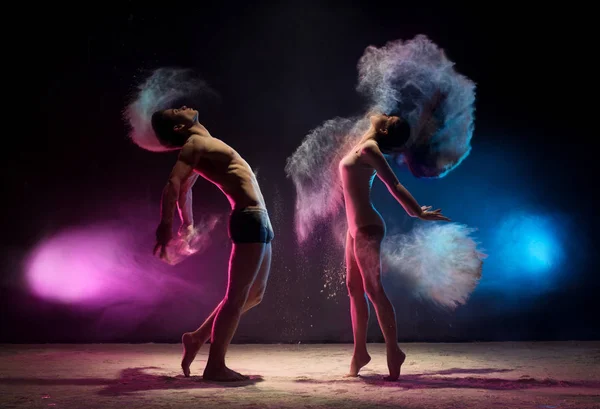 Νεαρό ζευγάρι πόζες στο πλάνο studio σύννεφο σκόνης χρώματος — Φωτογραφία Αρχείου