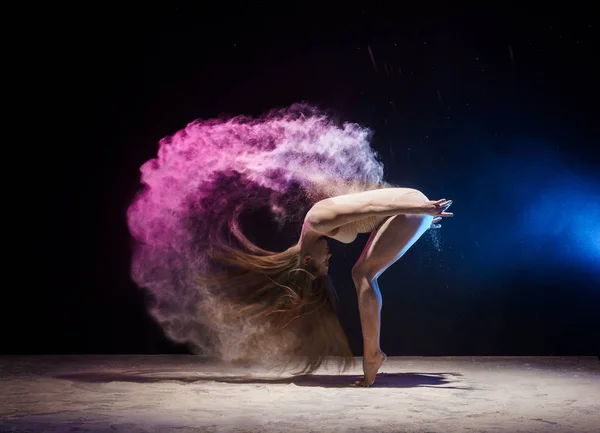 Půvabná gymnastka v oblaku barevného prachu — Stock fotografie