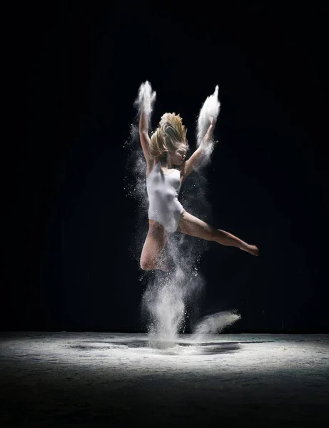 Mujer elegante saltando en la nube de polvo blanco — Foto de Stock