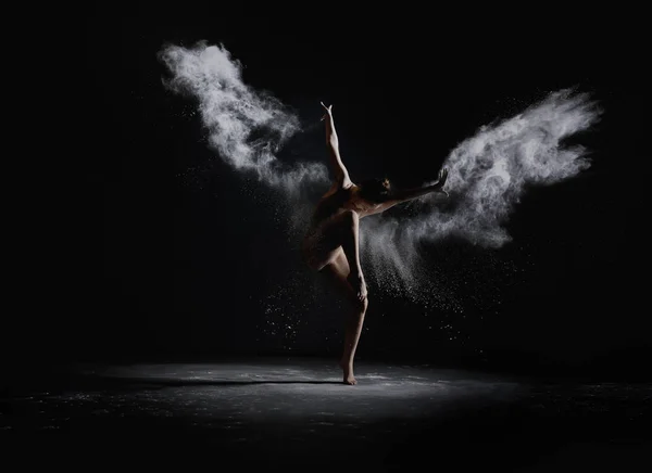 Menina esbelta dançando na nuvem de poeira branca — Fotografia de Stock