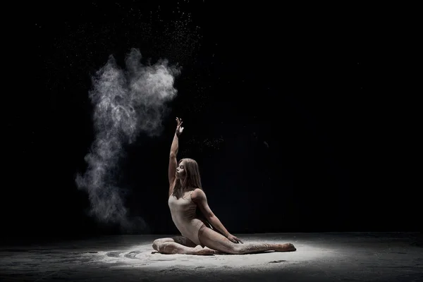 Chica elegante posando en la nube de polvo blanco en el estudio — Foto de Stock