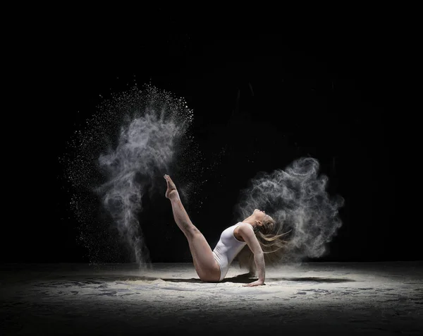 Sierlijke gymnast uitoefenen in de wolk van witte stof — Stockfoto