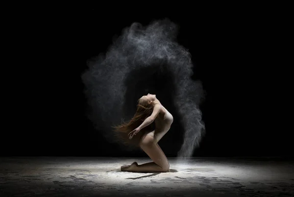 Chica elegante posando en la nube de polvo blanco en el estudio — Foto de Stock