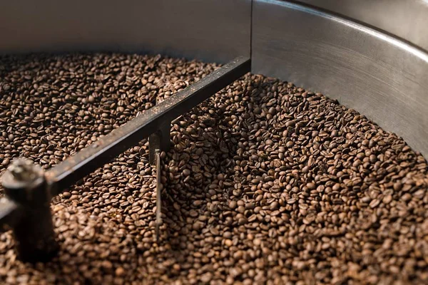 Coffee beans sifted and stirred in roasting machine — Stock Photo, Image