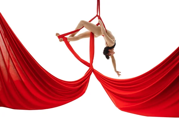 Jovem menina exercícios em sedas aéreas vermelhas no estúdio — Fotografia de Stock