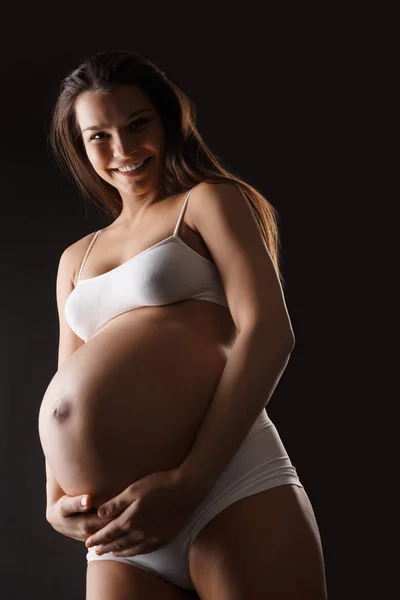 Zwangere jonge vrouw in lingerie uitzicht van onderen — Stockfoto