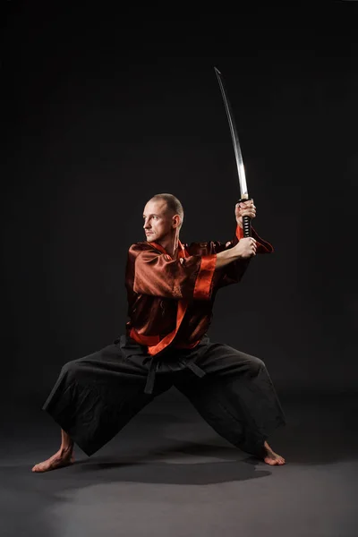 Homme en costume chinois avec épée studio portrait — Photo