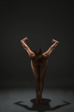 Üstsüz altın tenli kadın zarif bir şekilde dans ediyor