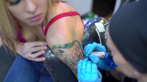 Сексуальная блондинка и мастер татуировки, рисующий тигра — стоковое видео