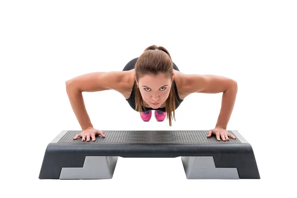 Treinador de fitness jovem exercitando na plataforma de passo — Fotografia de Stock