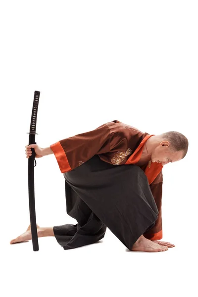 Homem em chinês tradicional em estúdio com uma espada — Fotografia de Stock