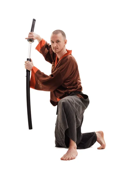 Homem em chinês tradicional em estúdio com uma espada — Fotografia de Stock