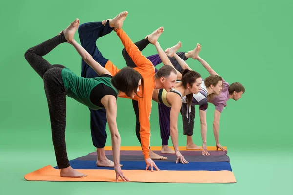 Hombres y mujeres hacen yoga en estudio fondo verde —  Fotos de Stock