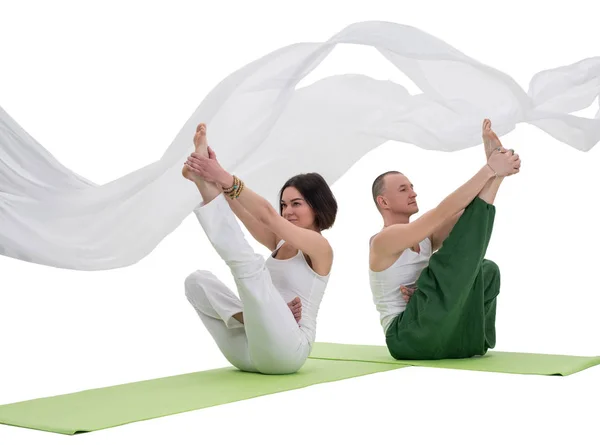 Casal fazendo exercício de ioga em estúdio tiro isolado — Fotografia de Stock
