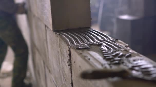 Worker building a wall of aerated concrete blocks — Stock Video