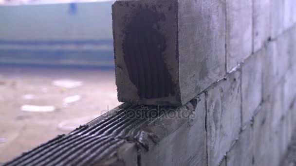 Werknemer bouwt een muur van belucht betonblokken — Stockvideo