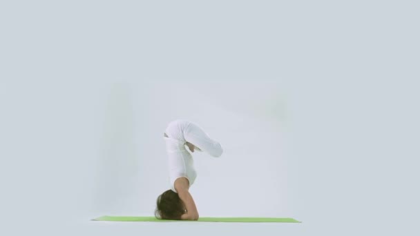 Frau macht Yoga-Handstand auf Matte im Studio — Stockvideo