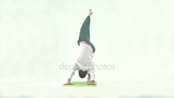 Hombre guapo haciendo gimnasia de yoga en el estudio — Vídeos de Stock