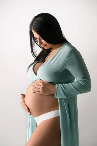 Belle brune enceinte tournée en robe bleue fine — Photo