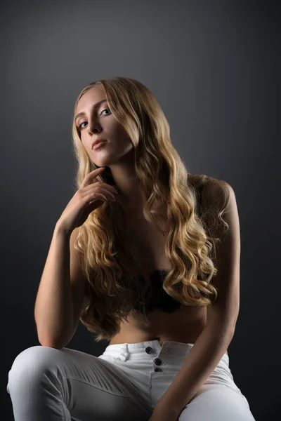 Сексуальна блондинка на кубику в білих худих джинсах і бюстгальтері — стокове фото