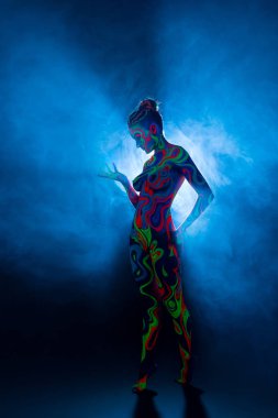 Stüdyoda morötesi renk desenli çarşaf giyen kız.