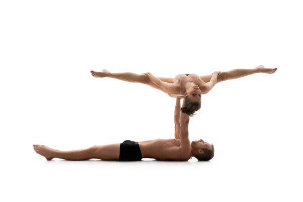 Male acrobat exercises with young girl in studio — Stock Photo, Image