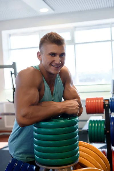 Junge hübsche Bodybuilder posiert in einem Fitnessstudio — Stockfoto