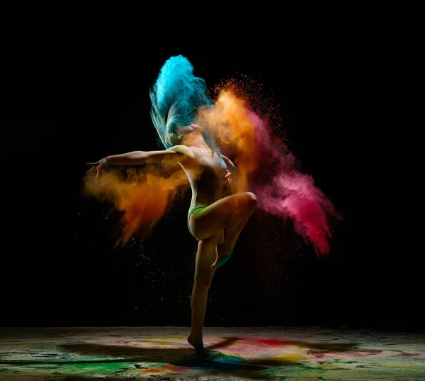 Дівчина танцює в хмарі кольорового пилу студійний портрет — стокове фото