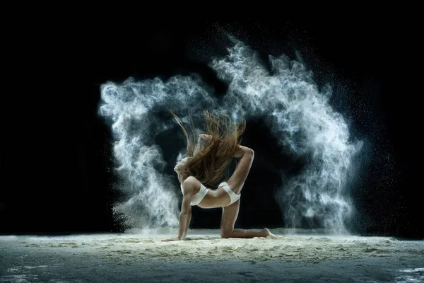 Sexy girl in a cloud of white dust studio portrait