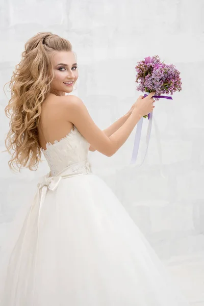 Jeune mariée fine en studio lançant son bouquet — Photo