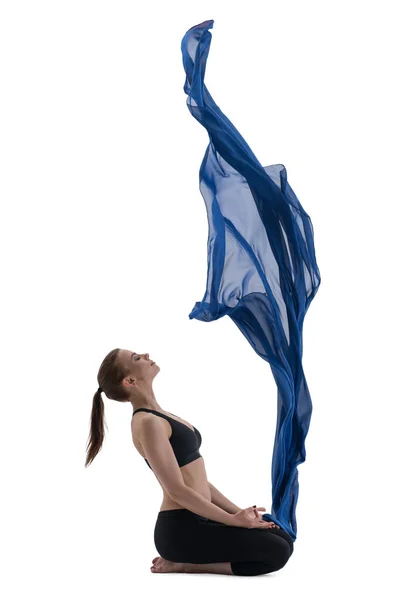 Довольно стройная девушка смотрит на голубой летающий вверх ткань — стоковое фото