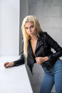 İnce sarışın Studio pencere pervazına yakınındaki poz