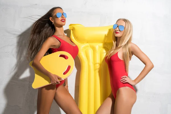 Две сексуальные девушки с плавательным матрасом в студии — стоковое фото