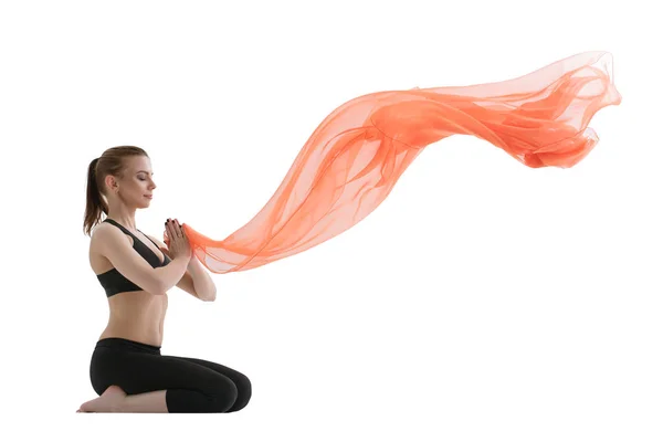 Yuong chica haciendo yoga posando con tela roja — Foto de Stock