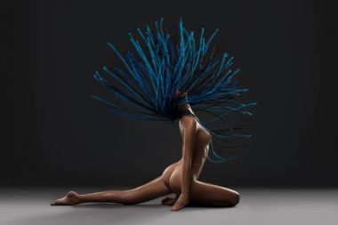 Bir bölünme içinde oturan dreadlocks çıplak kız