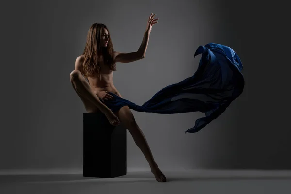 Morena delgada con tela posando desnuda sobre un cubo — Foto de Stock