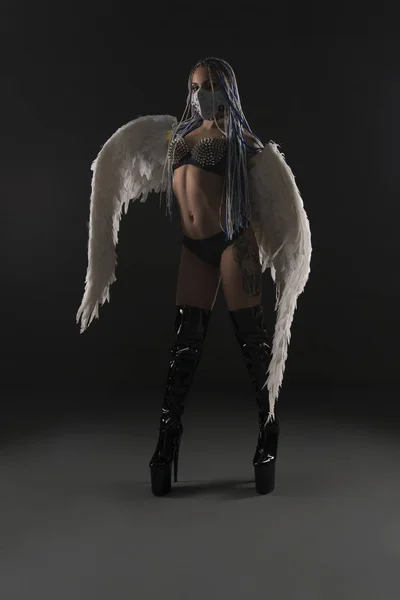 Slim girl with wings and in bdsm mask and belts — Stock Photo, Image