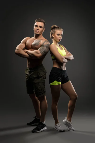 Seksi genç fitness çift gri arka plan üzerinde ateş — Stok fotoğraf