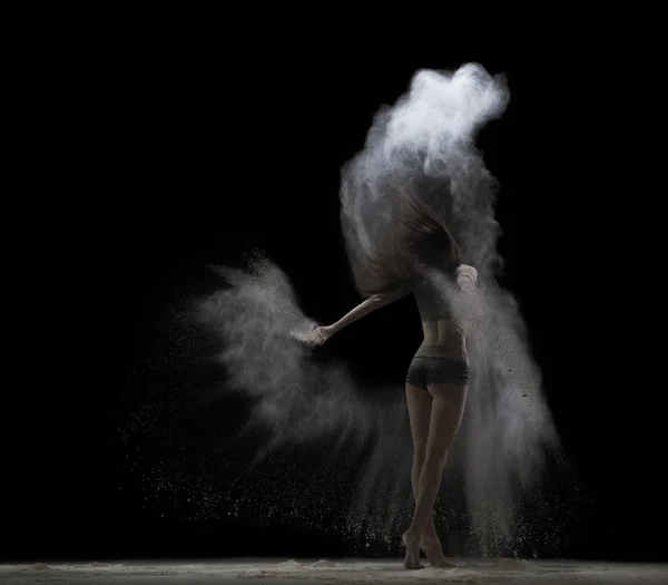 Young woman jumping in white dust cloud rearview — Stock Photo, Image