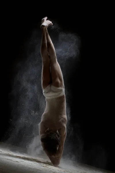 Man doet handstand in een wolk van de witte stof schot — Stockfoto