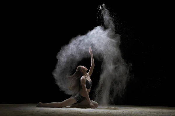Atış ince beyaz toz bulutu içinde oturan genç kadın — Stok fotoğraf