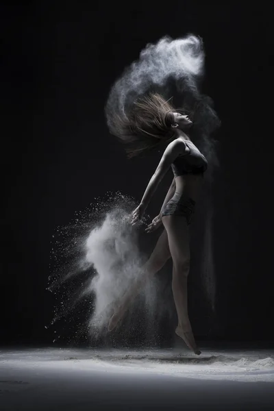 Slim ragazza che salta in bianco polvere nuvola vista — Foto Stock
